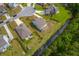Backyard view featuring an outdoor fire pit, wooden fence, and proximity to a small stream surrounded by a lush green area at 5497 Alpine Dr, Summerville, SC 29483
