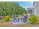 Cozy backyard area with Adirondack chairs arranged around a stone fire pit, perfect for relaxing evenings at 5497 Alpine Dr, Summerville, SC 29483