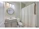 This bathroom includes a shower and tub, a round mirror, and a white toilet at 5497 Alpine Dr, Summerville, SC 29483
