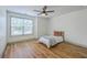 Bright bedroom with a ceiling fan, wood-look floors, and natural light streaming through the large window at 5497 Alpine Dr, Summerville, SC 29483