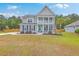 Inviting two-story home with a double porch, pristine landscaping, and a charming coastal design at 5497 Alpine Dr, Summerville, SC 29483