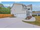 Side view of a charming two-story home showcasing the garage and well-maintained landscaping at 5497 Alpine Dr, Summerville, SC 29483