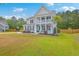 Inviting two-story home with a double porch, pristine landscaping, and a charming coastal design at 5497 Alpine Dr, Summerville, SC 29483