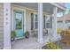 Charming front porch with inviting seating and a pop of color with a turquoise door at 5497 Alpine Dr, Summerville, SC 29483