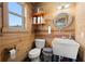 Rustic bathroom featuring wood paneled walls, round mirror, and vessel sink with faucet at 5653 Wire Rd, Branchville, SC 29432