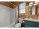 Bright bathroom with shower-tub, granite vanity top, commode, and wood-paneled walls at 5653 Wire Rd, Branchville, SC 29432