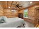 Well lit bedroom features wood paneling, ceiling fan, and a view to the outside at 5653 Wire Rd, Branchville, SC 29432
