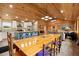 Large dining area adjacent to the kitchen features a long table, wood paneling, and modern lighting at 5653 Wire Rd, Branchville, SC 29432