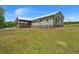 Lush lawn surrounds this waterfront home, complete with a covered porch for enjoying the serene landscape at 5653 Wire Rd, Branchville, SC 29432