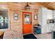 Bright kitchen featuring wood paneling, an orange door, white cabinets, and modern appliances at 5653 Wire Rd, Branchville, SC 29432
