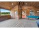 Large covered patio with wooden ceiling, fishing equipment and orange door at 5653 Wire Rd, Branchville, SC 29432