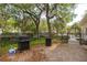 An outdoor grilling area with a gas grill, trash can, and green space at 600 Bucksley Ln # 305, Charleston, SC 29492
