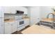 Well-lit kitchen with white cabinets, stainless steel sink, and updated appliances at 600 Bucksley Ln # 305, Charleston, SC 29492