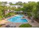 An in-ground swimming pool surrounded by lounge chairs and trees at 600 Bucksley Ln # 305, Charleston, SC 29492