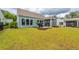 Spacious backyard featuring a patio area with a grill, lush green grass, and a fenced perimeter at 6176 Wilkes Pond Dr, Hollywood, SC 29449