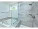 Modern bathroom featuring a luxurious tub with a glass enclosure and stylish gray tile at 6176 Wilkes Pond Dr, Hollywood, SC 29449