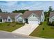 Well-maintained home with manicured front lawn and a convenient two-car garage and spacious driveway at 6176 Wilkes Pond Dr, Hollywood, SC 29449