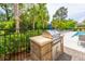 Outdoor grill area with a built-in grill perfect for barbecues and entertaining, set amidst lush landscaping near the pool at 6176 Wilkes Pond Dr, Hollywood, SC 29449