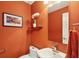 Powder room featuring terra-cotta walls, a white vanity, and a framed canyon landscape art piece at 679 Clearview Dr, Charleston, SC 29412