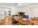 Bright dining room with hardwood floors, featuring a wooden table, kitchen access, and a vintage piano at 679 Clearview Dr, Charleston, SC 29412