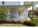 A cozy porch with a white railing, comfortable seating, and colorful flowers in the landscaped yard at 679 Clearview Dr, Charleston, SC 29412