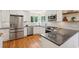 A modern kitchen features stainless steel appliances, white cabinets, granite countertops, and hardwood floors at 679 Clearview Dr, Charleston, SC 29412