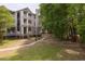 Exterior of a three-story building with white railings and stairs, nestled among mature trees and a winding sidewalk at 700 Daniel Ellis Dr # 4104, Charleston, SC 29412
