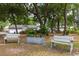 Outdoor common area featuring benches and a planter surrounded by mature trees, providing a relaxing gathering spot at 700 Daniel Ellis Dr # 4104, Charleston, SC 29412