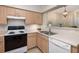 Corner kitchen features tile backsplash, white appliances, and wood cabinets at 700 Daniel Ellis Dr # 4104, Charleston, SC 29412