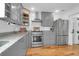 Charming kitchen featuring stainless steel appliances and stylish gray cabinets at 71 Cypress St, Charleston, SC 29403