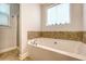 Bathtub featuring tile accents, a shower, and window at 7414 Purser Ln, Hanahan, SC 29410