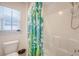 Bright bathroom with a toilet and a shower with a blue and green patterned shower curtain at 7414 Purser Ln, Hanahan, SC 29410