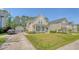 This home has light yellow siding, blue shutters, a quaint front porch, and well-manicured landscaping at 7414 Purser Ln, Hanahan, SC 29410