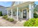 Inviting front porch with stylish columns, light blue shutters, and decorative plants enhances the home's curb appeal at 7414 Purser Ln, Hanahan, SC 29410