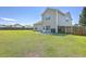 Well-maintained home exterior and large, level backyard featuring green grass and a fenced perimeter for added privacy and security at 7477 Painted Bunting Way, Hanahan, SC 29410