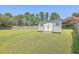 Spacious backyard featuring a charming shed, green grass, and a fenced perimeter for added privacy and security at 7477 Painted Bunting Way, Hanahan, SC 29410