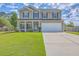 Two-story home boasts a spacious lawn and driveway leading to an attached two car garage at 7477 Painted Bunting Way, Hanahan, SC 29410