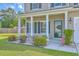 Charming front entrance with well-manicured landscaping, a security system sign, and green shutters at 7477 Painted Bunting Way, Hanahan, SC 29410