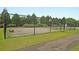 Outdoor basketball court surrounded by black chainlink fence, with lush green trees, and a paved walking path at 81 Crossandra Ave, Summerville, SC 29483