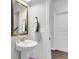 Powder room featuring pedestal sink with gold fixtures, mirror, and stylish decor at 81 Crossandra Ave, Summerville, SC 29483