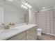 Bathroom with dual sink vanity, modern lighting, and shower with curtain at 81 Crossandra Ave, Summerville, SC 29483