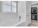 Bright bathroom with a soaking tub next to a window with shutters and a walk-in closet at 81 Crossandra Ave, Summerville, SC 29483