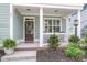 Inviting front porch with classic white columns, lush landscaping, and a cozy seating area at 81 Crossandra Ave, Summerville, SC 29483