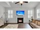 Cozy living room with a fireplace, ceiling fan, and plantation shutters on the windows at 81 Crossandra Ave, Summerville, SC 29483