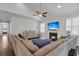 Inviting living room with a fireplace, large sectional sofa, and vaulted ceilings with ceiling fan at 81 Crossandra Ave, Summerville, SC 29483