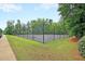 Community tennis court enclosed by a fence and surrounded by trees at 81 Crossandra Ave, Summerville, SC 29483