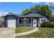 Charming blue home with a white porch, green lawn, and attached garage at 8268 Timberidge Ct, North Charleston, SC 29420