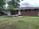 View of the front yard with a single story brick house with green shutters at 10 Cranford Rd, Goose Creek, SC 29445