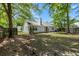 Spacious backyard featuring a well-maintained lawn, mature trees, and a quaint patio perfect for outdoor enjoyment at 102 Amberside Dr, Goose Creek, SC 29445