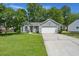 Charming single Gathering home with a lush lawn, mature trees, and a two-car garage at 102 Amberside Dr, Goose Creek, SC 29445